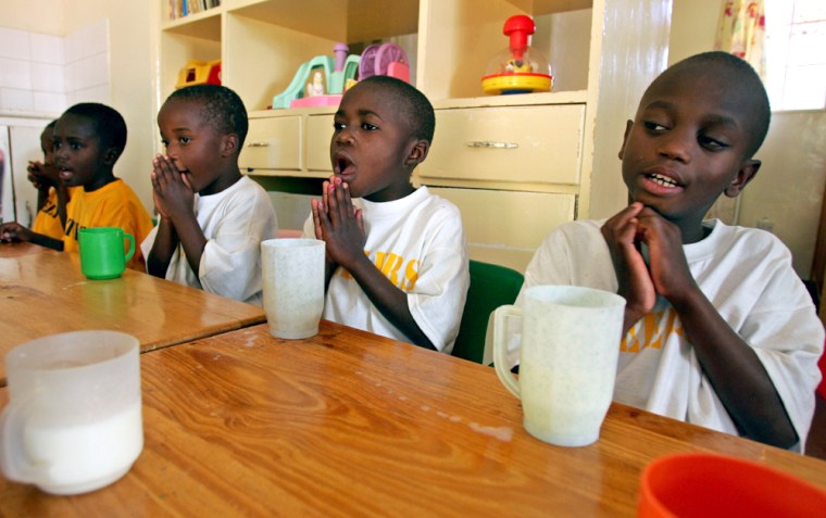 HIV positive orphans pray before having a glass of milk at Nyumbani hospice in Nairobi