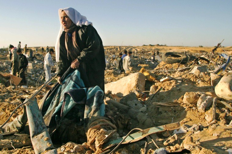 A Palestinian woman recovers household goods from the rubble on Sunday after Israeli troops withdrew from a section of the Khan Younis refugee camp in the Southern Gaza Strip.