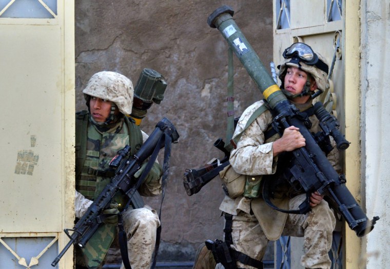 During an afternoon of sporadic battling with insurgents, U.S. Marines waiting to advance take shelter inside the gateway of a home, in Ramadi on Monday.