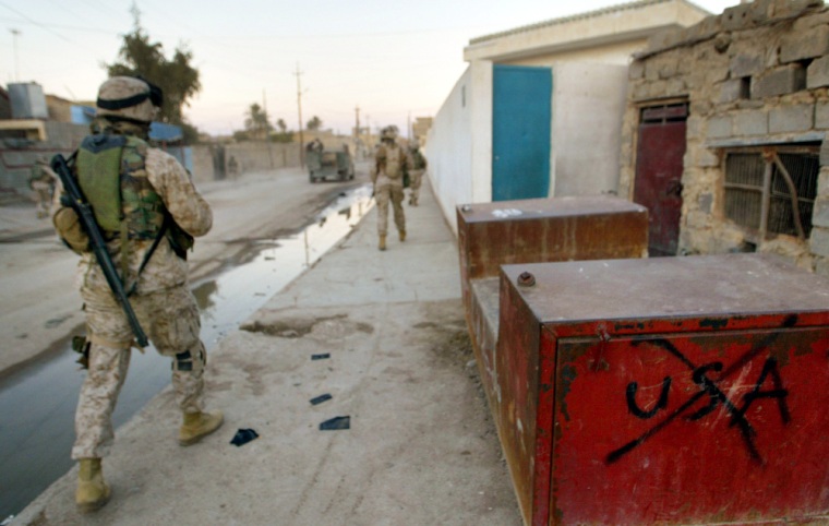 U.S. Marines walk past anti-American graffiti in Ramadi, Iraq, on Tuesday.