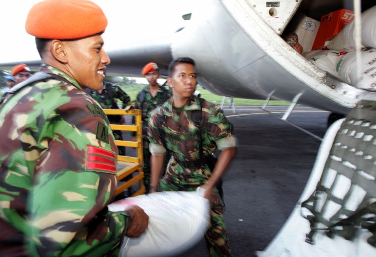 Indonesian soldiers loads sacks of food aid onto a plane heading for Banda Aceh at Medan's military airport