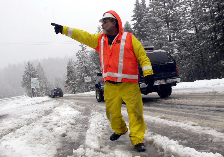 Caltrans employee Richard Ramos turns traffic around on Interstate 80 near Alta, Calif., on Thursday morning. A slow-rolling series of storms battered the American West this week.