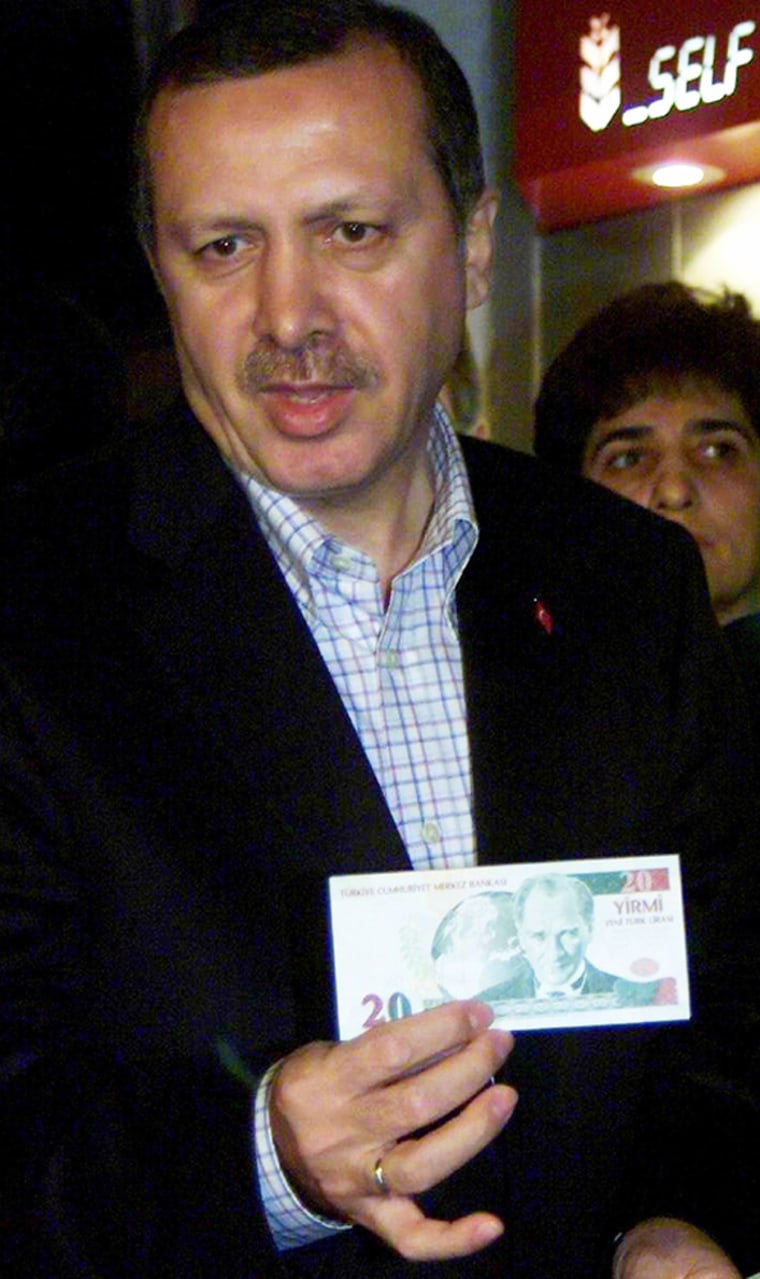 Turkish Prime Minister Erdogan displays a new 20 New Turkish Liras (YTL) banknote