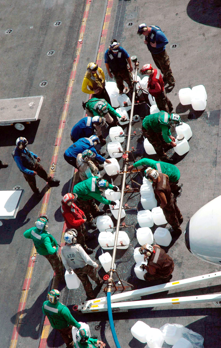 050109-N-9293K-009Indian Ocean (Jan. 9, 2005) - Crew members aboard USS Abraham Lincoln (CVN 72) fill jugs with purified water from a Potable Water Manifold. The Repair Division aboard Lincoln constructed the manifold in eight hours. The water jugs will be flown by Navy helicopters to regions isolated by the Tsunami in Sumatra, Indonesia. Helicopters assigned to Carrier Air Wing Two (CVW-2) and Sailors from Abraham Lincoln are supporting Operation Unified Assistance, the humanitarian operation effort in the wake of the Tsunami that struck South East Asia. The Abraham Lincoln Carrier Strike Group is currently operating in the Indian Ocean off the waters of Indonesia and Thailand. U.S. Navy photo by Photographer's Mate 3rd Class Jacob J. Kirk (RELEASED)