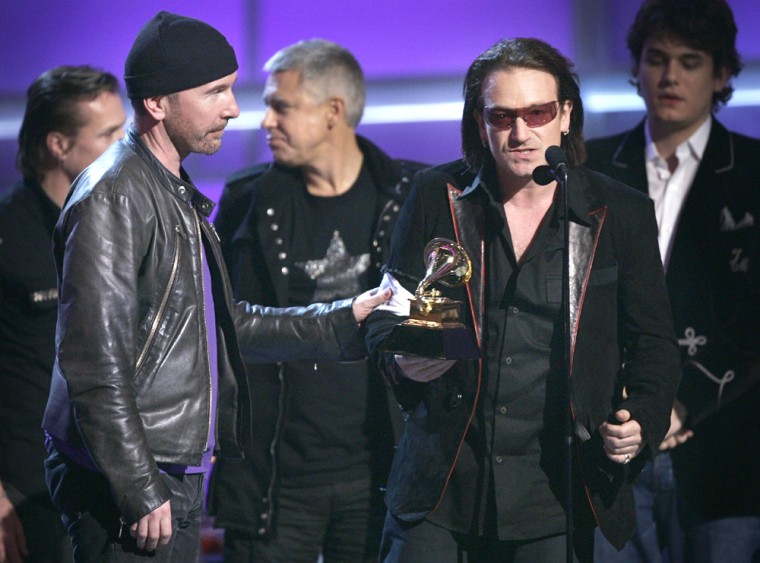 Bono, right, The Edge, left, and the group U2 accept their awards for best rock performance by a duo or group with vocal for \"Vertigo\" at the 47th Annual Grammy Awards on Sunday, Feb. 13, 2005, at the Staples Center in Los Angeles. At right rear is presenter John Mayer. (AP Photo/Kevork Djansezian)