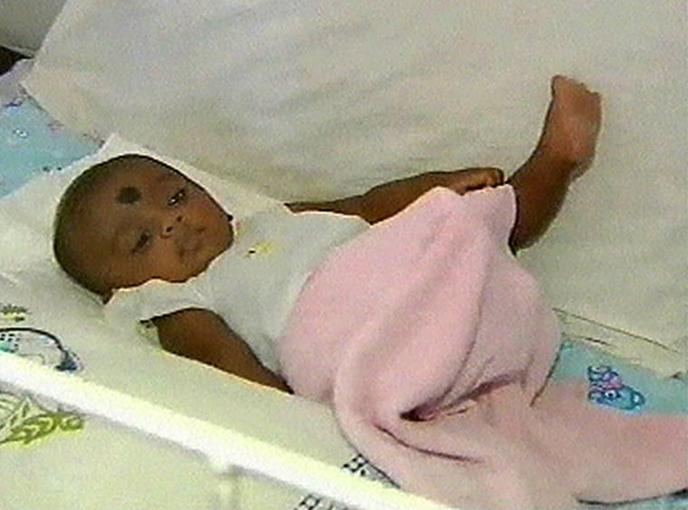 In this image from television, the infant boy known as "Baby 81" is seen in a crib at the hospital in Kalmunai, Sri Lanka, on Wednesday.