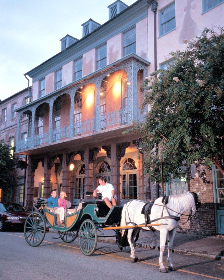 A couple takes a carriage ride in front of Historic Dock Street Theater, in Charleston, S.C.