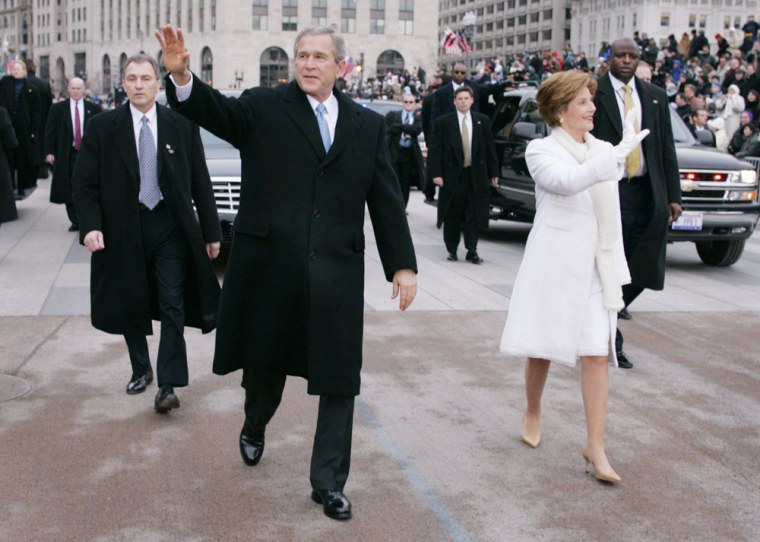 President Bush and first lady Laura Bush walk during the inauguration parade Thursday in front of the White House.