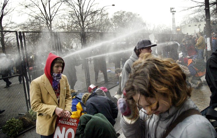 Police fire pepper spray into crowd of protestors as Bush inaugural parade passes