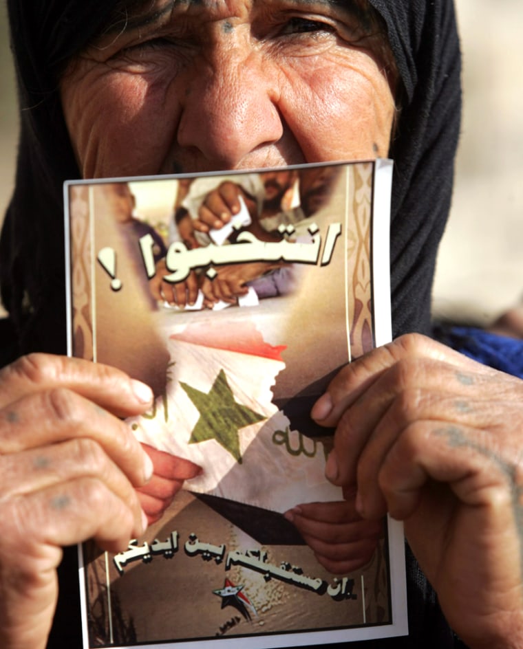 An Iraqi woman holds a poster urging Iraqis to vote in the upcoming January 30 national elections