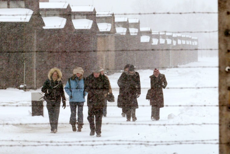 Visitors walk inside former death camp Auschwitz II-Birkenau during a heavy snow storm in Oswiecim