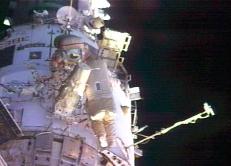 Leroy Chiao and Salizhan Sharipov installed an experimental robotic arm and inspected vents Wednesday during the first spacewalk of their mission.