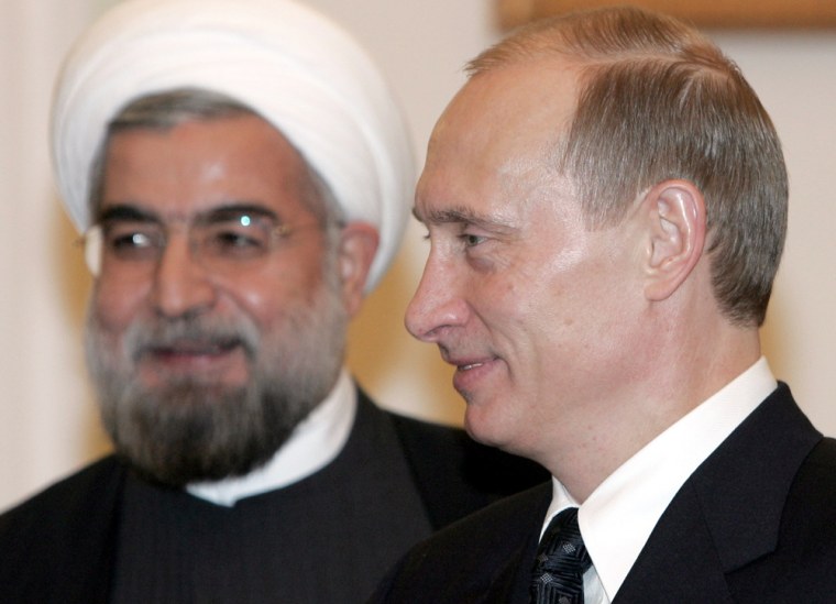 Russian President Putin stands with Iranian chief nuclear negotiator Rohani in the Moscow's Kremlin