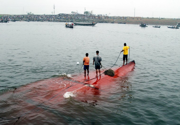 Firemen wait for a rescue boat during an attempt to salvage a sunken ferry in the Buriganga river, Bangladesh