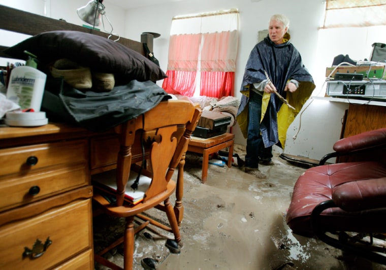 Don Kuhli collects his belongings after a mud slide filled his apartment.