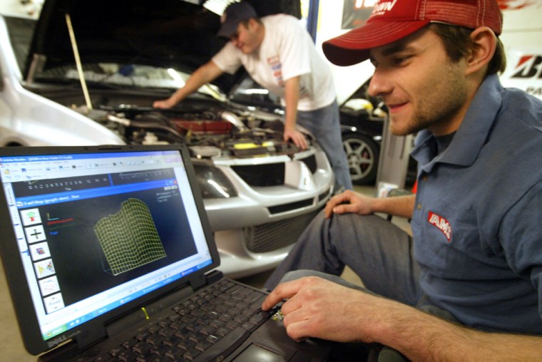 Mike Anders, co-owner of Atlantic Motorsports, adjusts the timing on a Mitsubishi Lancer EVO using advanced software and a data log.