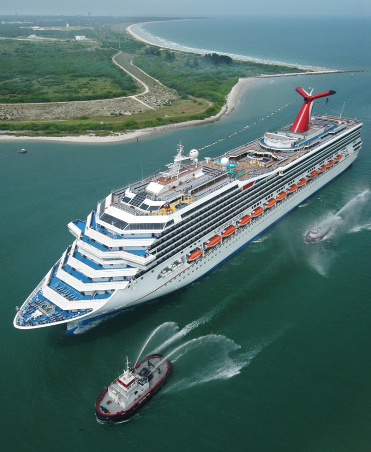 Escorted by water-squirting tugs, the new Carnival Glory passes the Kennedy Space Center as she arrives in Cape Canaveral, Fla., on July 11, 2003. Carnival, the world's largest cruise company, had its most profitable year ever in 2004 and expects to do better this year.