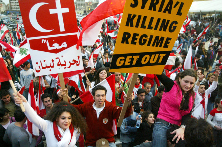 Lebanese protesters carry placards against Syria in Beirut