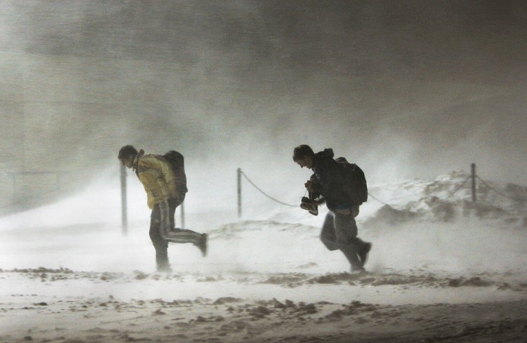 Strong wind and blowing snow make for a rough walk as these two leave the athletic center at Harvard University in Cambridge, Mass., on Tuesday night.