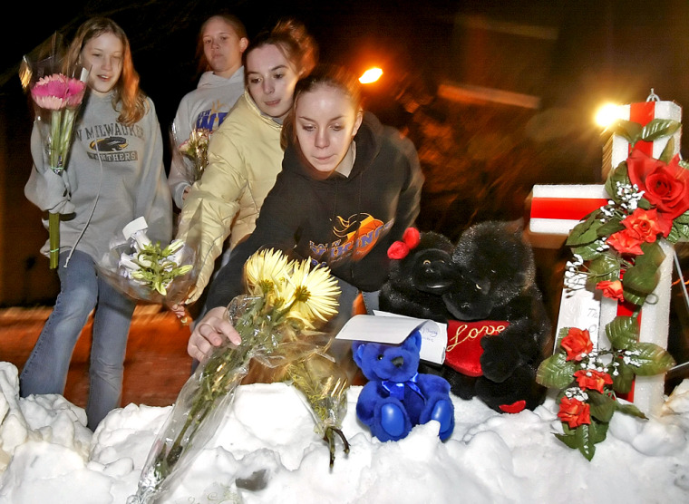 Chelsey Porth, left to right, Kaitlin Schaeren, Ariel Reuter and Kelly Rooney all of New Berlin, Wis., leave flowers outside the Sheraton Hotel Saturday, March 12, 2005, in Brookfield, Wis. A gunman opened fire Saturday at a church service being held at the hotel, killing at least eight people and wounding several others, police said. The gunman then apparently shot and killed himself, Brookfield Police Chief Daniel Tushaus said. (AP Photo/Morry Gash)