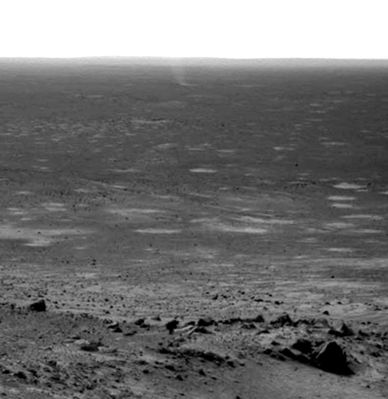 A mini-whirlwind known as a dust devil can be seen near the horizon, at center in this picture taken by the Spirit rover's navigation camera.