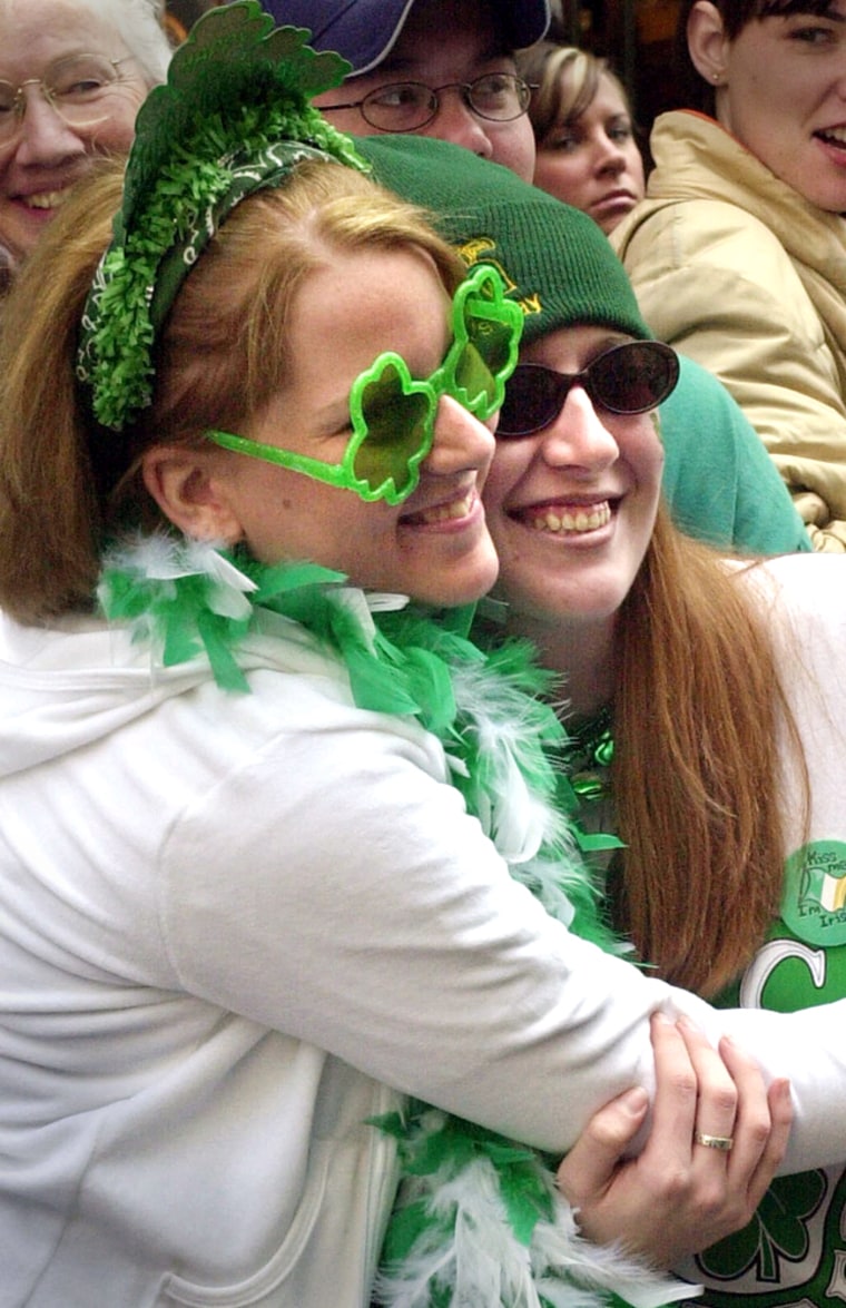 Women embrace as they watch the annual St. Patrick's Day parade along New York City's Fifth Avenue , Monday, March 17, 2003. Despite evidence of heightened police security and the possible war with Iraq, thousands of revelers lined the parade route, taking advantage of the spring-like weather. (AP Photo/Ed Bailey)