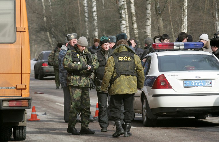 Police officers and Federal Security Service agents confer at a highway 29 km ( about 18 miles) west of Moscow, at the site of an assassination attempt Thursday, March 17, 2005. Anatoly Chubais, the head of Russia's state-controlled electricity monopoly, who authored the nation's massive post-Soviet privatization, survived an assassination attempt Thursday when unidentified attackers detonated a powerful explosive device and then fired at his car as he was heading to work from his country home just west of Moscow. (AP Photo)