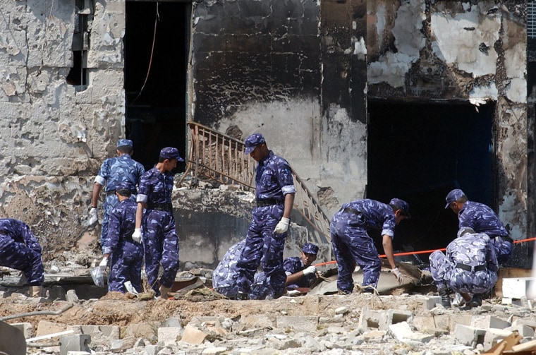 Security personnel inspect the site of an explosion at the Doha Players Theater on Sunday.