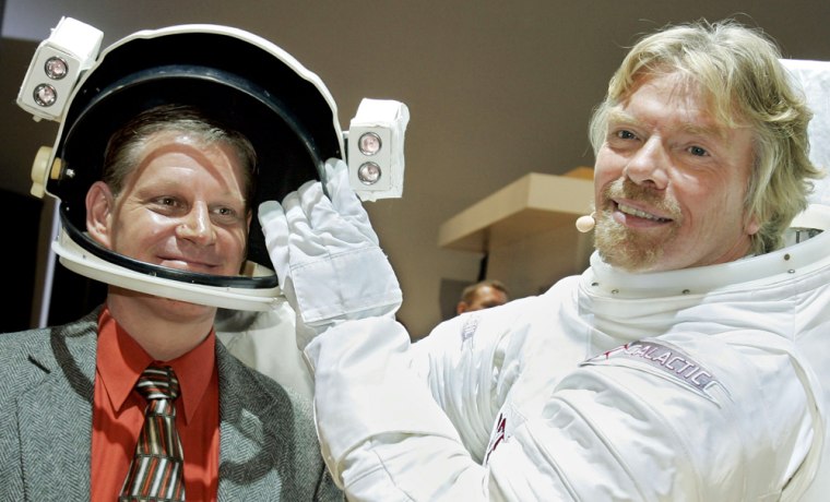 Virgin Galactic founder Richard Branson, right, takes the helmet off his spacesuit and puts it on Doug Ramsburg, the winner of a ticket giveaway for a future suborbital space voyage. Volvo sponsored the sweepstakes and announced the winner's name Thursday at a New York auto show.