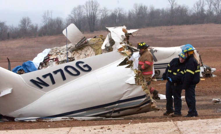 Officials stand near the wreckage of a single-engine plane that crashed Saturday near Bellefonte, Pa. The crash happened as the pilot was attempting a landing approach, officials said.