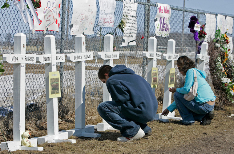 Chongai'la Morris, left and Alex Roy place ritual tobaco at a makeshift memorial outside the Red Lake Senior High School in Red Lake, Minn., Friday.