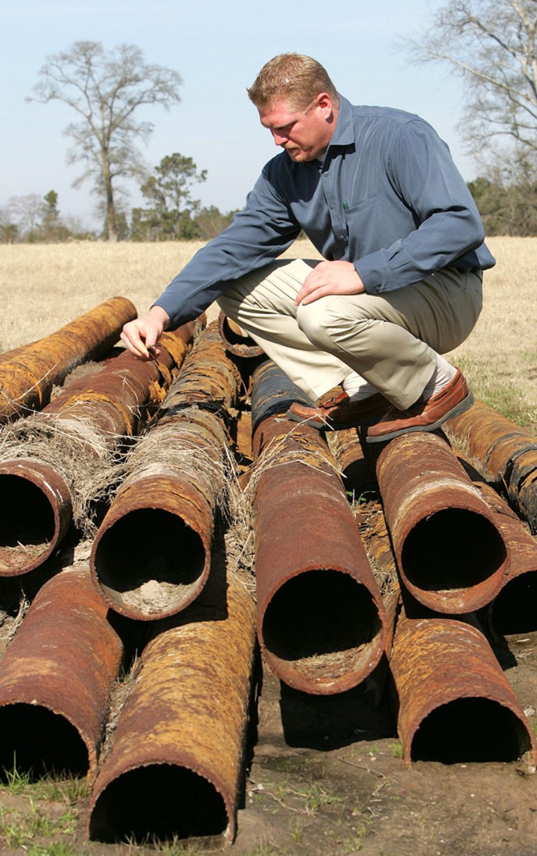 Developer David Frankens inspects some of the abandoned Chevron pipeline that his crew dug up over a year ago near Lufkin, Texas. 