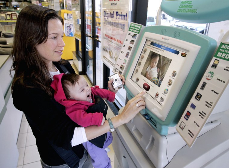 Jesse Eisenberg of New York City uses a Fuji Film digital photo kiosk at B&H Photo to print a picture from her digital camera of her 12-week old daughter Shea. While there's no hint of a falloff in the desire of Americans to freeze-frame the world around them, the overall number of images converted into prints has been slipping.
