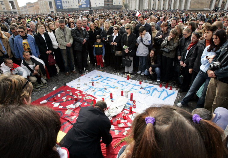 Polish pilgrims gather next to their national flag Sunday as thousands of people crowd St. Peter's Square in Rome during a Mass for the repose of Pope John Paul II's soul. 