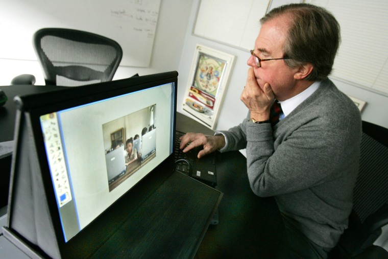 Nicolas Negroponte, founder and chairman of MIT's Media Lab, works on a prototype of a $100 computer for children in the developing world.