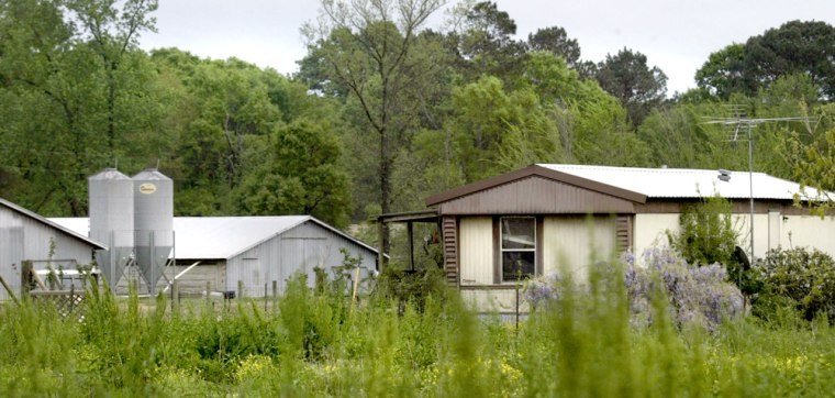 Chicken houses at left are shown near a mobile home, right, where  escaped convict Randolph Dial and an assistant warden's wife, Bobbie Parker were living in Campti, Texas, Tuesday, April 5, 2005. A tip generated by the TV  show \"America's Most Wanted\" led law enforcement to Dial. (AP Photo/Donna McWilliam)