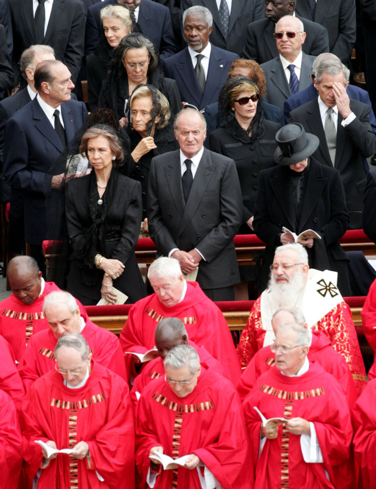 President Bush, right center, touches his forehead during the funeral of Pope John Paul II in St. Peter's Square at the Vatican on Friday. Standing to his left are first lady Laura Bush, Bernadette Chirac and French President Jacques Chirac.