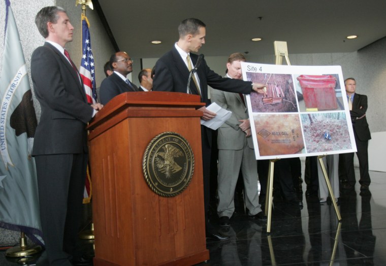U.S. Attorney David Nahmias, left, listens Wednesday at the Richard B. Russell Federal Building in Atlanta as FBI Special Agent Todd Letcher shows photos of bomb-making material and dynamite found in western North Carolina. Eric Rudolph admitted hiding them.