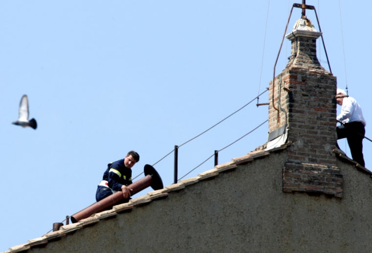 Workers install the chimney on the roof of the Sistine Chapel at the Vatican on Friday.
