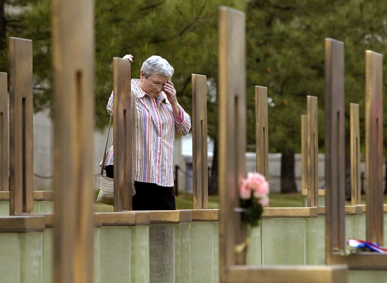 Woman reacts at daughters memorial chair at Oklahoma City National Memorial on eve of bombing anniversary