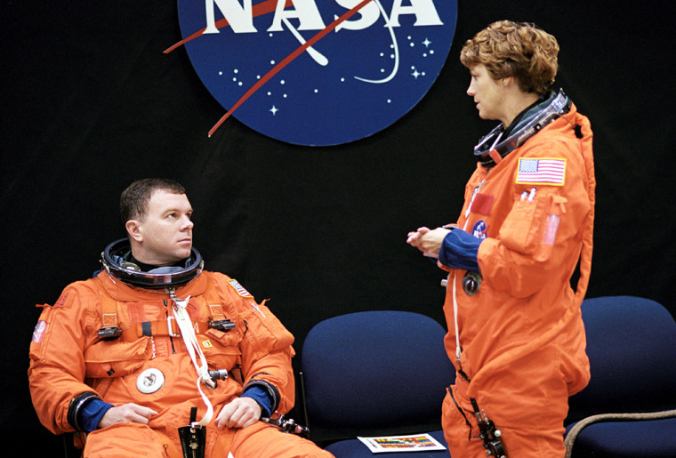 Astronauts James Kelly and Eileen Collins await the start of a training session in the Space Vehicle Mockup Facility at NASA's Johnson Space Center in Houston. Collins and Kelly are wearing training versions of the full-pressure launch and entry suit.