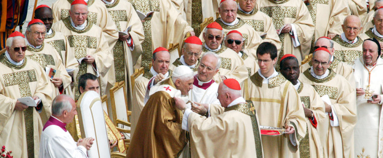 Cardinal Jorge Arturo Medina Estevez, center foreground, and Bishop Piero Marini, center without skull cap, place the pallium on Pope Benedict XVI as cardinals look on Sunday during his inaugural Mass in St. Peter's Square at the Vatican.
