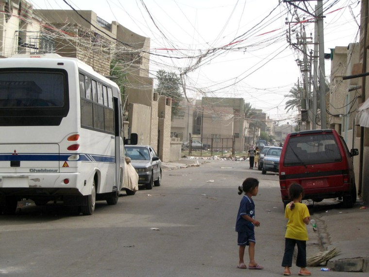 A web of power lines links homes to a privately operated neighborhood generator in Topchi, Iraq.
