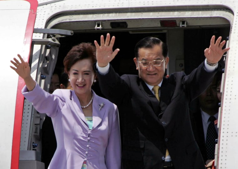 Taiwan's opposition leader Lien Chan and his wife wave goodbye as they board plane at Pudong airport in Shanghai