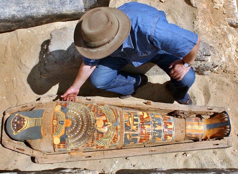 Zahi Hawass, chief of Egypt's Supreme Council of Antiquities, checks a brilliantly colored mummy dating back more than 2,300 years.