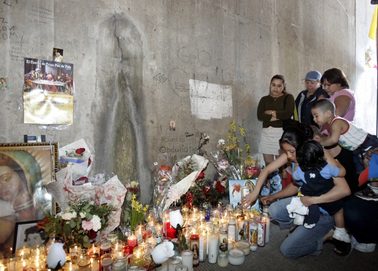 A family lights a candle at a section of