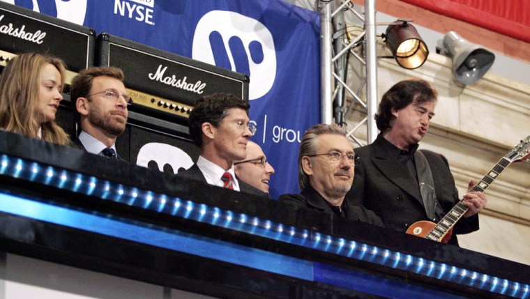 Led Zeppelin guitarist Jimmy Page, right, plays on the New York Stock Exchange podium during opening bell ceremonies for the IPO of Warner Music Group Corp. on Wednesday morning.