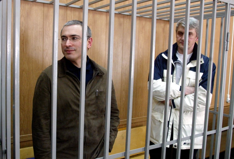 Former Yukos oil CEO Mikhail Khodorkovsky, left, with co-defendant and business partner Platon Lebedev, stand behind bars Monday at their Moscow trial on fraud and tax evasion.