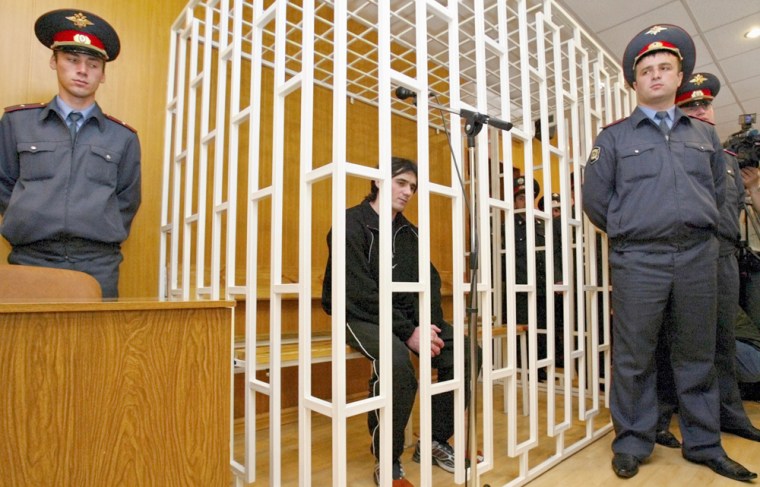 Nur-Pashi Kulayev, the sole known survivor from the militant group that seized a school last September in the southern Russian town of Beslan, listens behind bars to charges against him during the trial in Vladikavkaz, Northern Ossetia, Russia, on Tuesday.