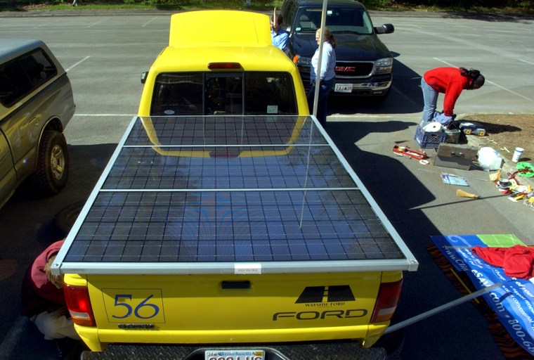 Students from St. Mark's school outside Boston work on their physics teacher's '94 Ford Ranger which is battery powered on Friday, May 13, 2005, in Saratoga Springs, N.Y., before its test at the 17th annual Tour de Sol. Solar panels, with batteries underneath are in the back of the truck.  (AP Photo/Jim McKnight)